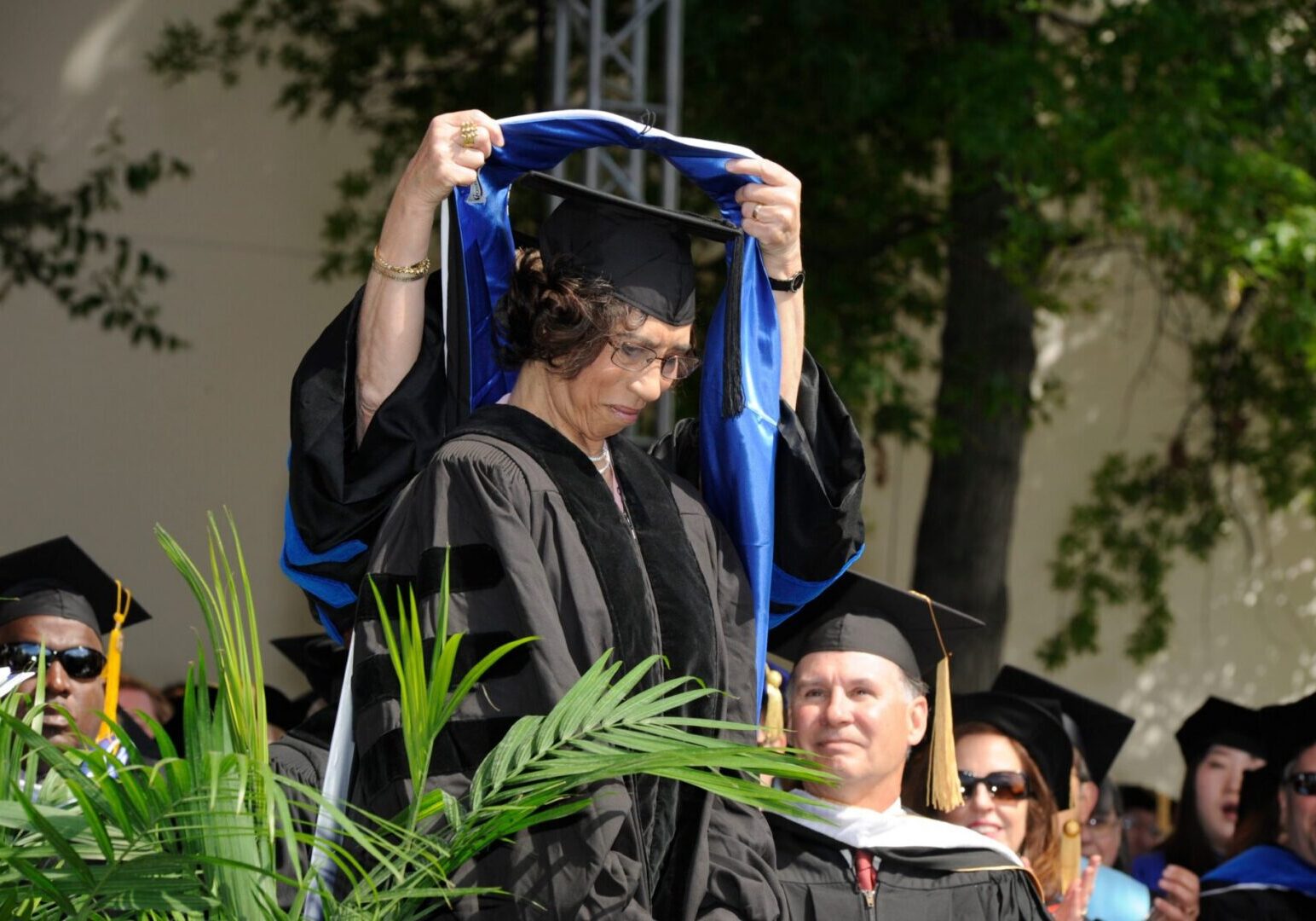 Graduate receiving doctoral hood outdoors