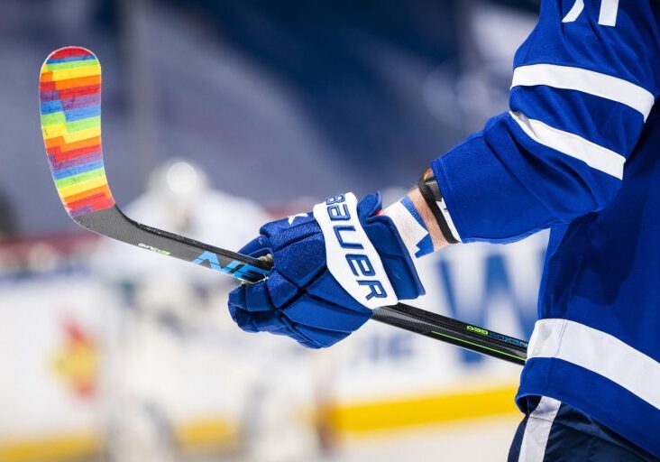 Blue hockey glove holding stick