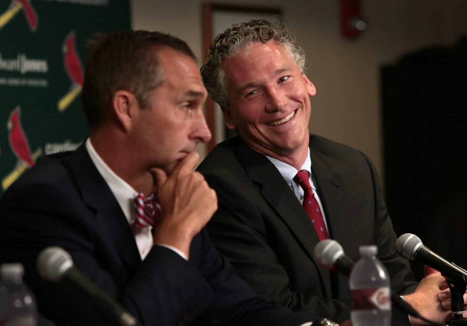 Smiling man in a suit at microphone