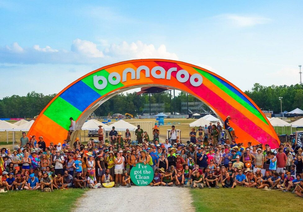 Festival crowd under colorful Bonnaroo arch
