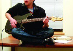 Person playing guitar on a table