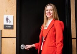 Smiling woman near restroom sign