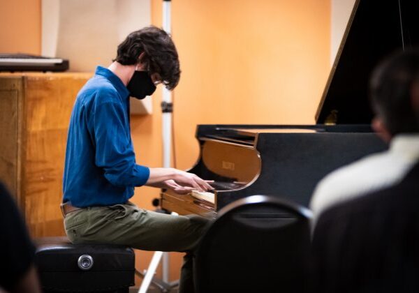 Musician with mask playing piano
