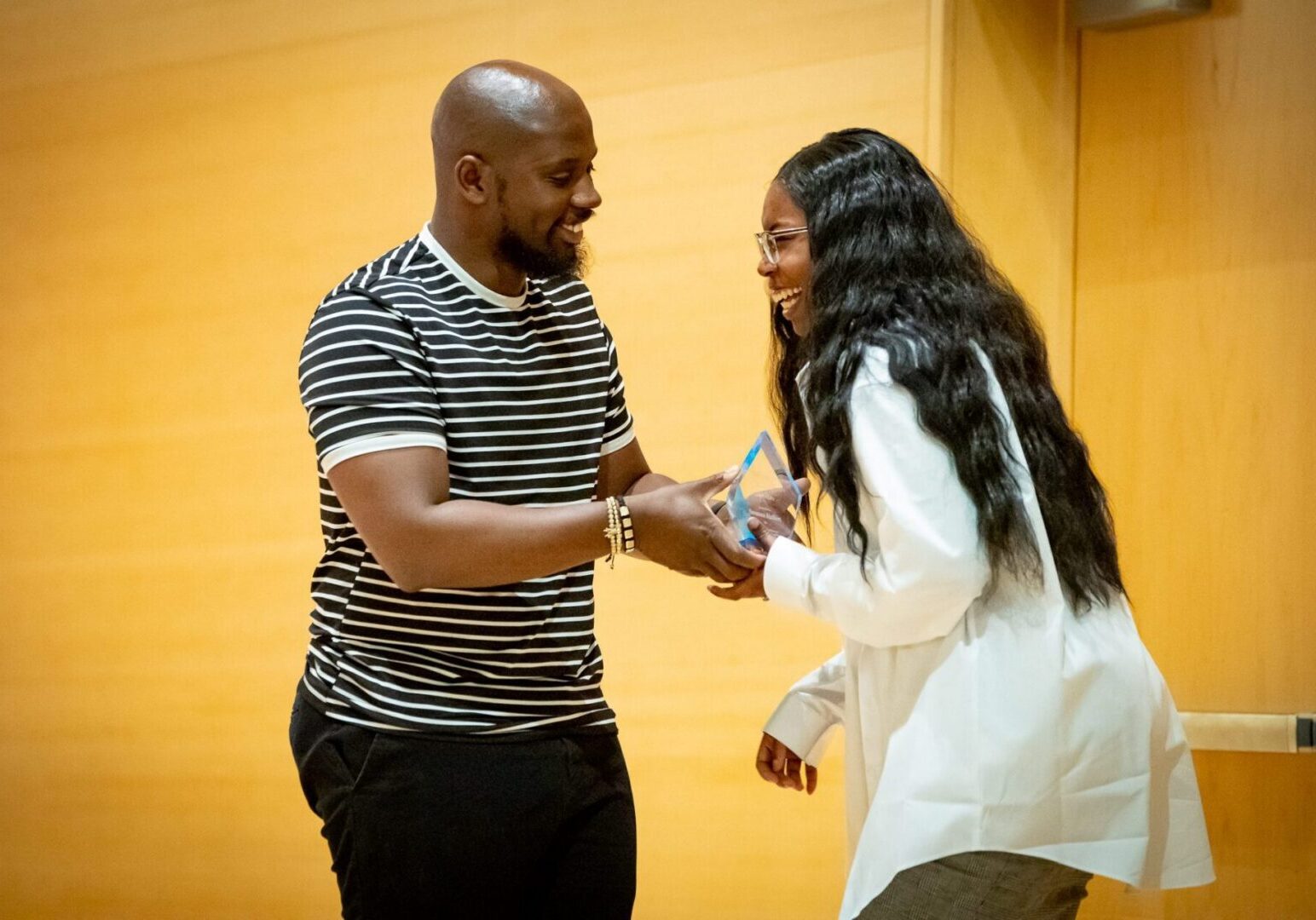 Man handing award to smiling woman