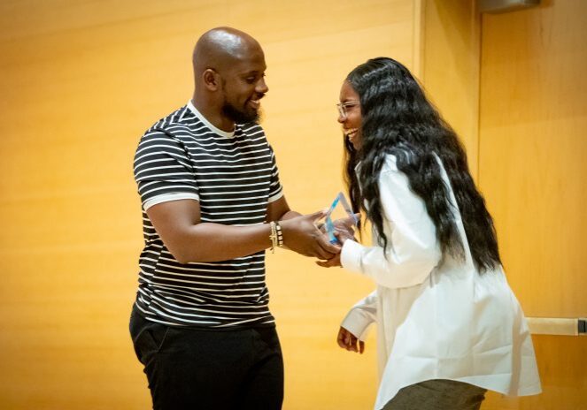 Man and woman exchanging an award