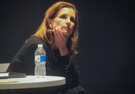 Woman sitting thoughtfully with hand on chin