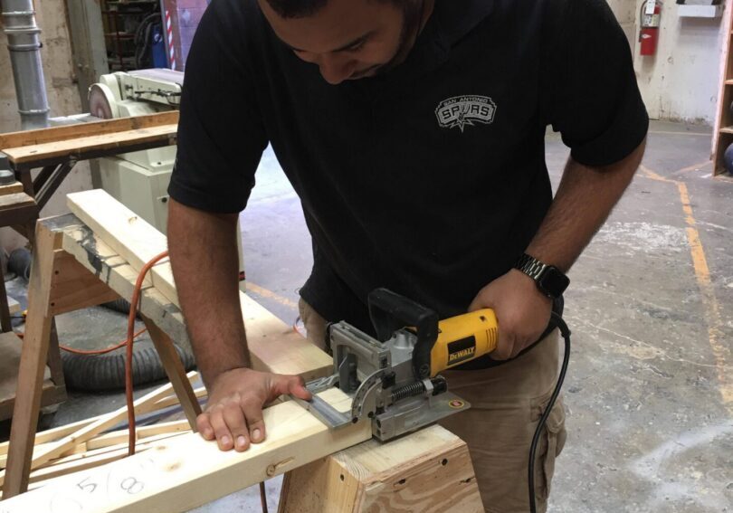 Carpenter cutting wood with electric saw