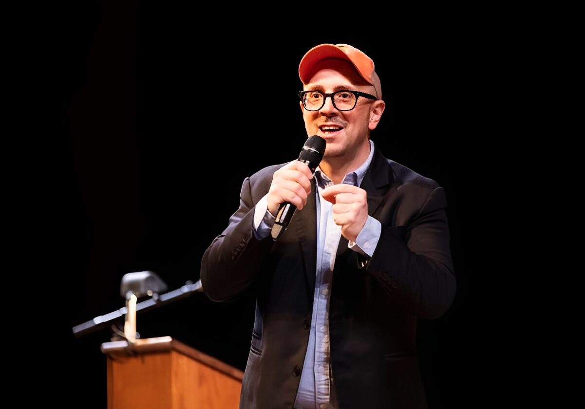 Man speaking on stage with microphone