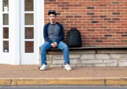 Man sitting on bench with backpack