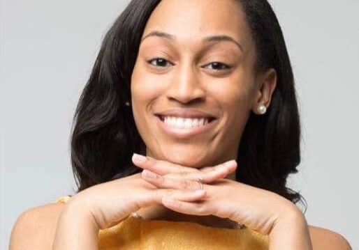 Smiling woman with hands under chin