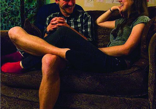 Friends sharing a laugh on sofa