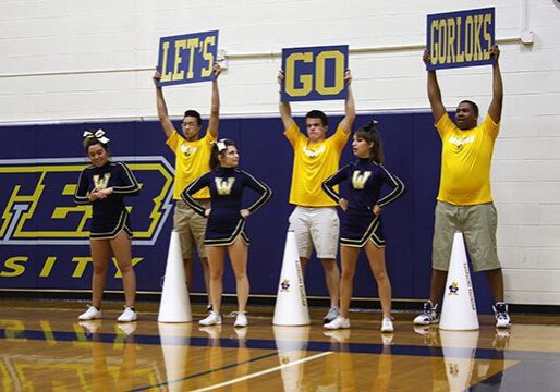 Cheerleaders holding motivational signs in gym