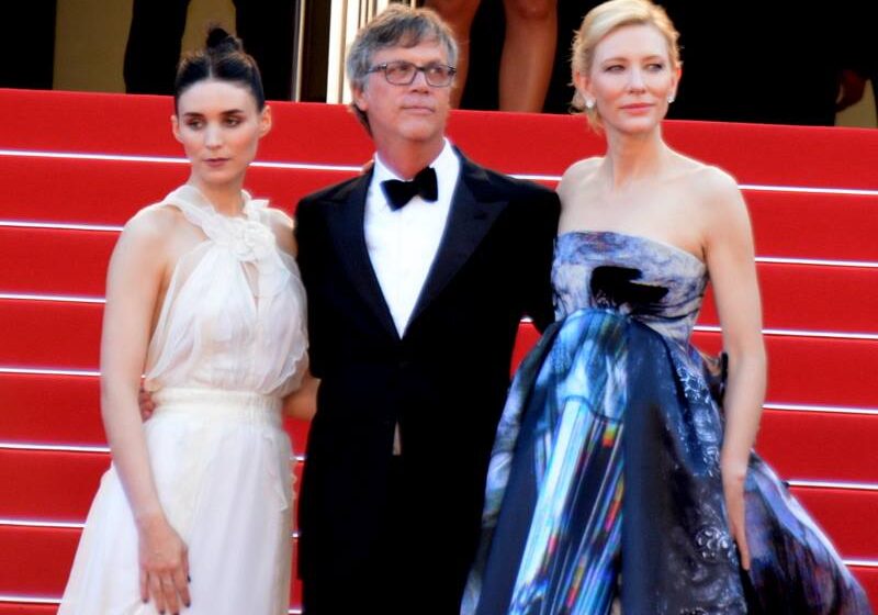 Three people posing on red carpet