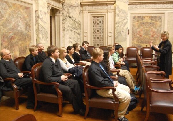 Lecture in ornate room with audience