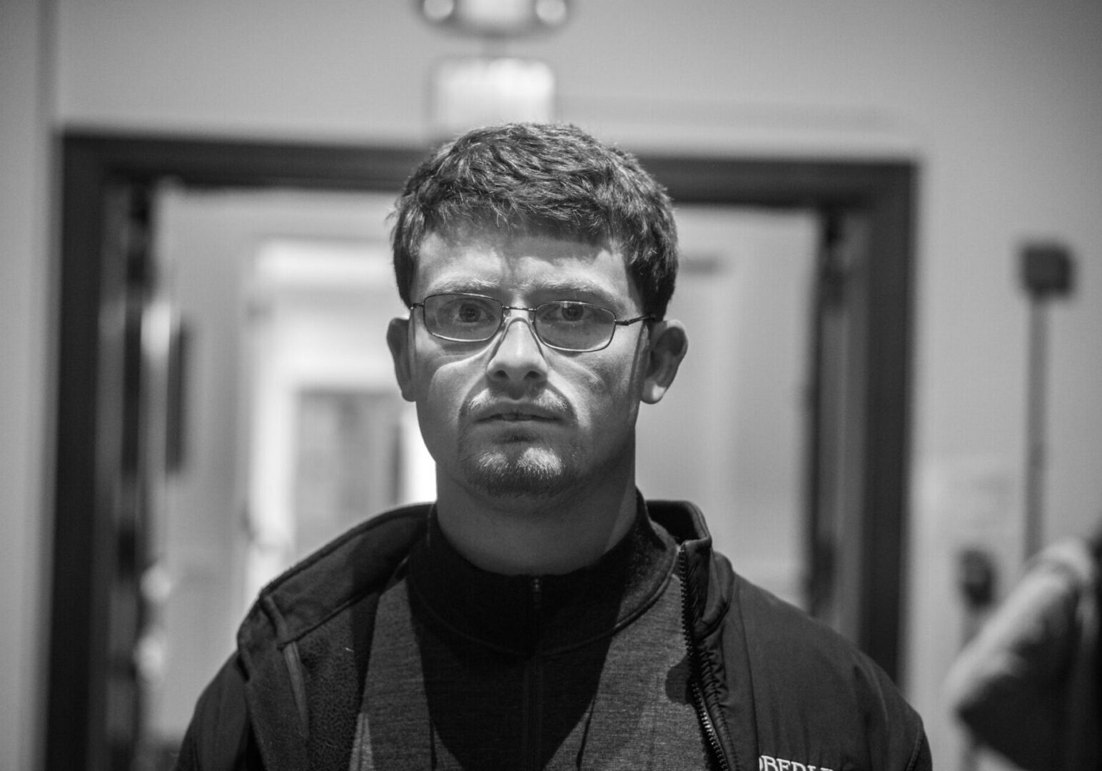 Man with glasses in a hallway