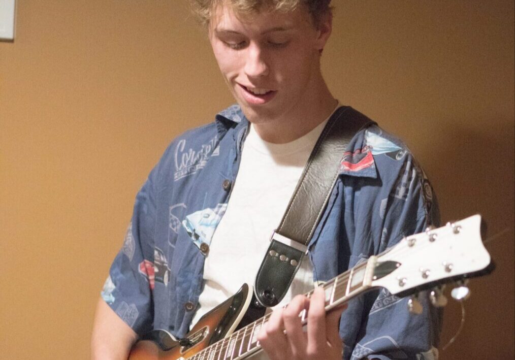 Person playing electric guitar indoors