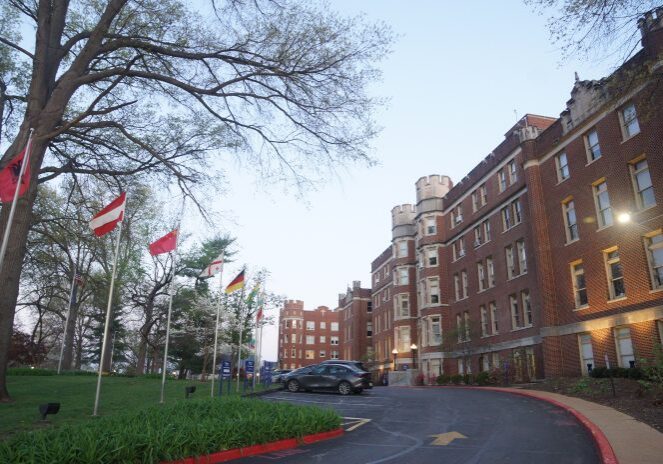 Historic building with flags and trees