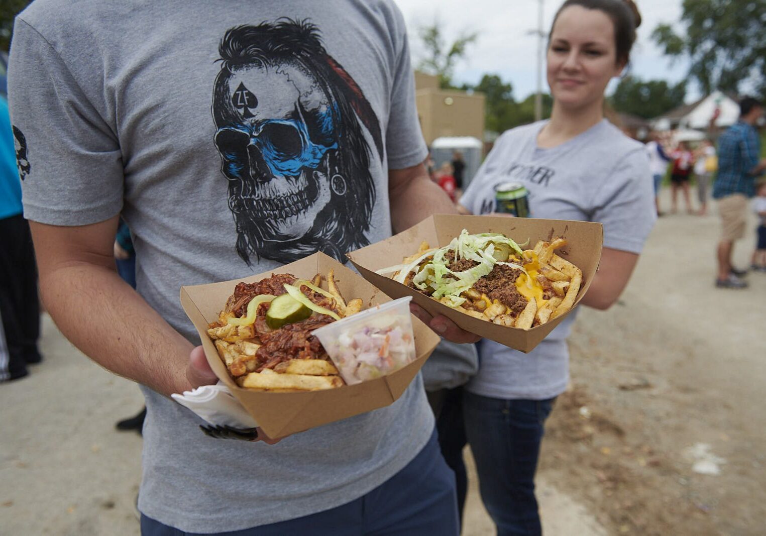 Person with fries and drink outdoors