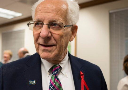 Man in glasses at an indoor event.