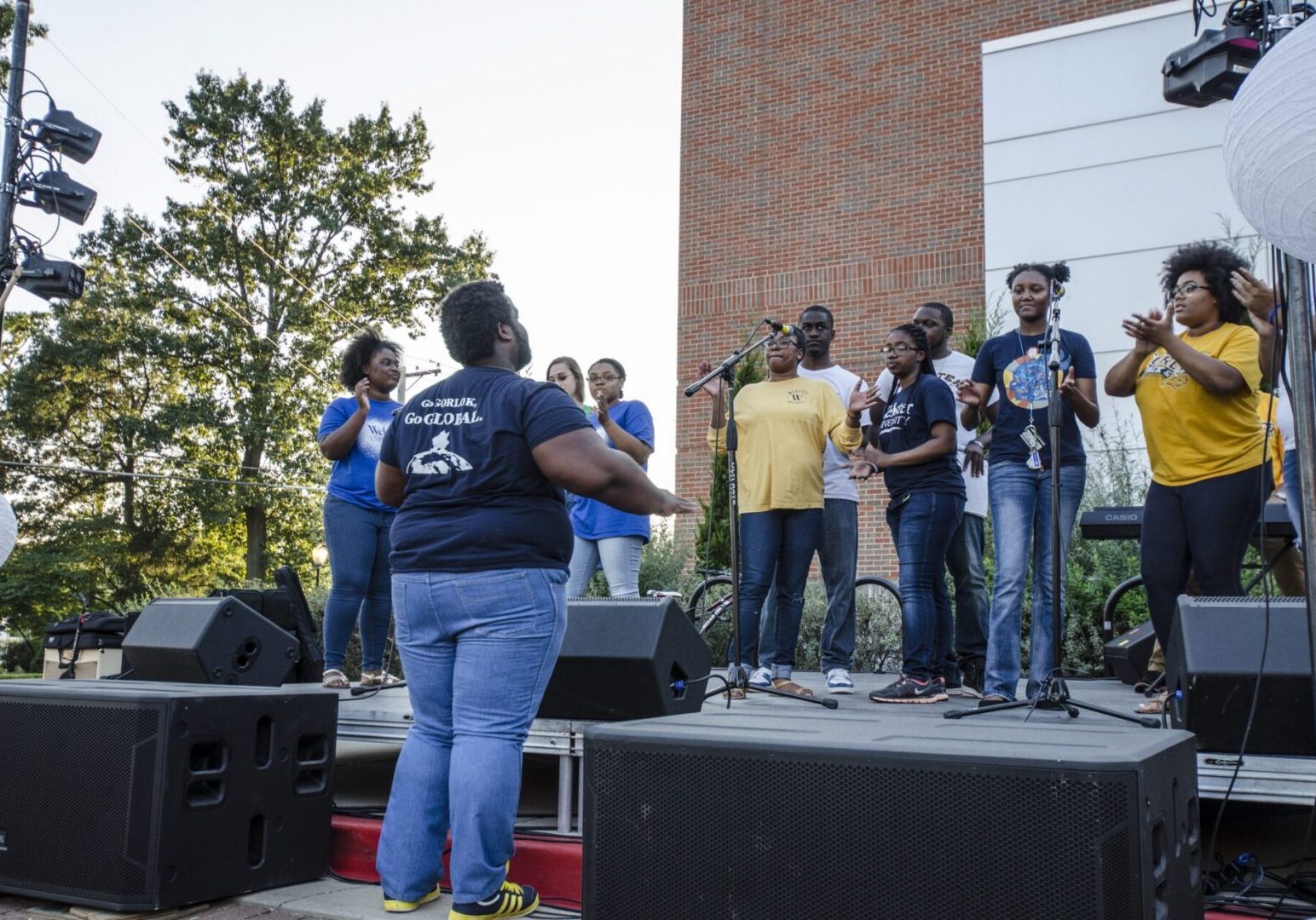 Group singing on stage outdoors
