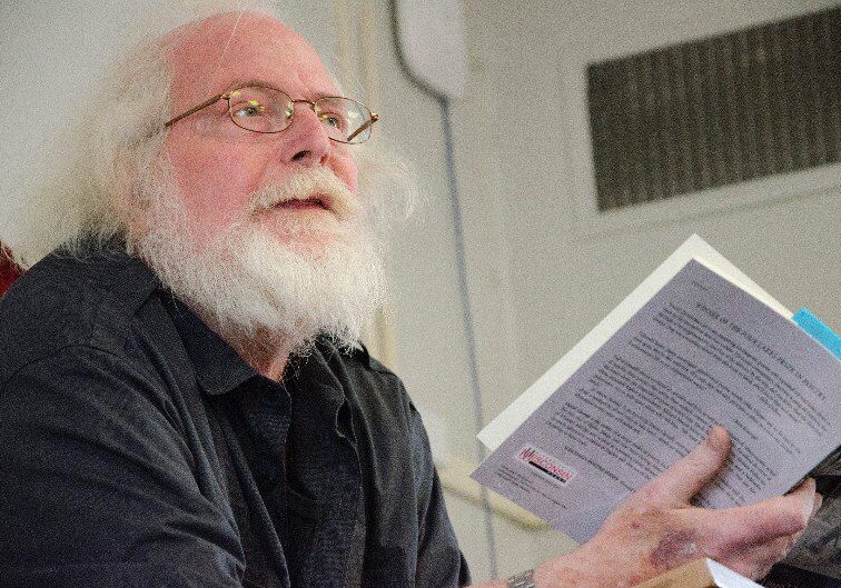 Elderly man reading a book aloud