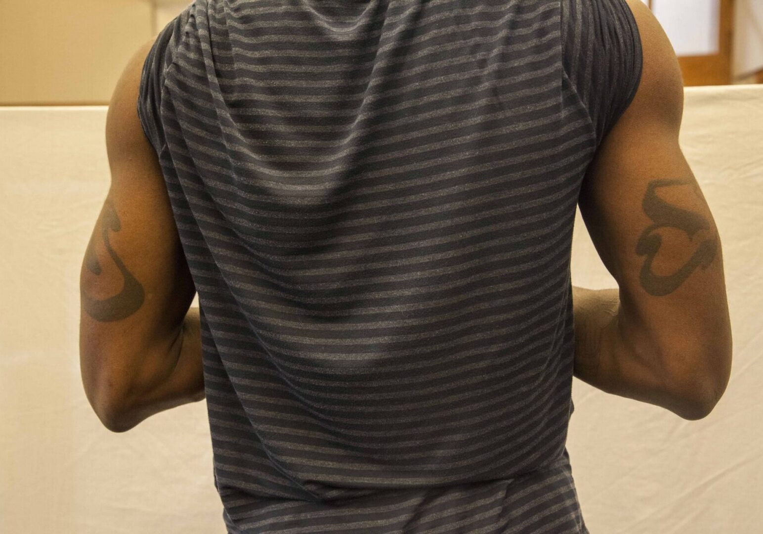 Man with tattoos wearing striped shirt