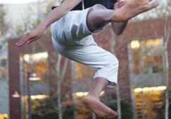 Man executing flying karate kick outdoors
