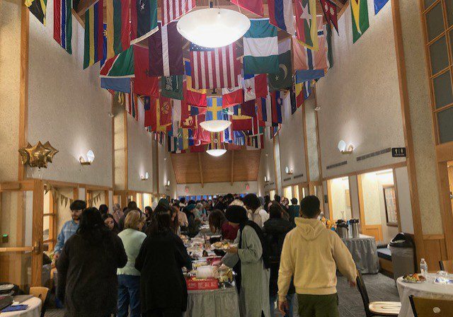 Group socializing in flag-decorated venue.