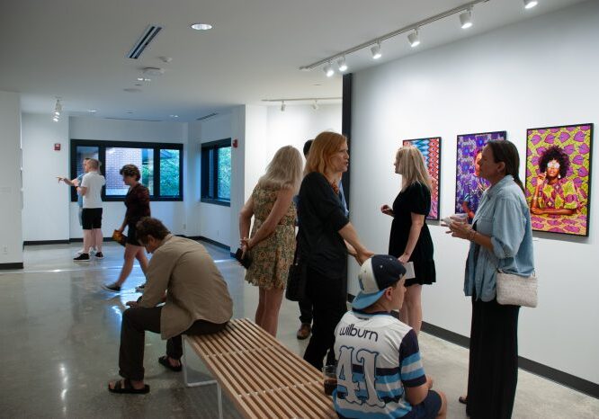 Visitors exploring vibrant artwork in exhibition