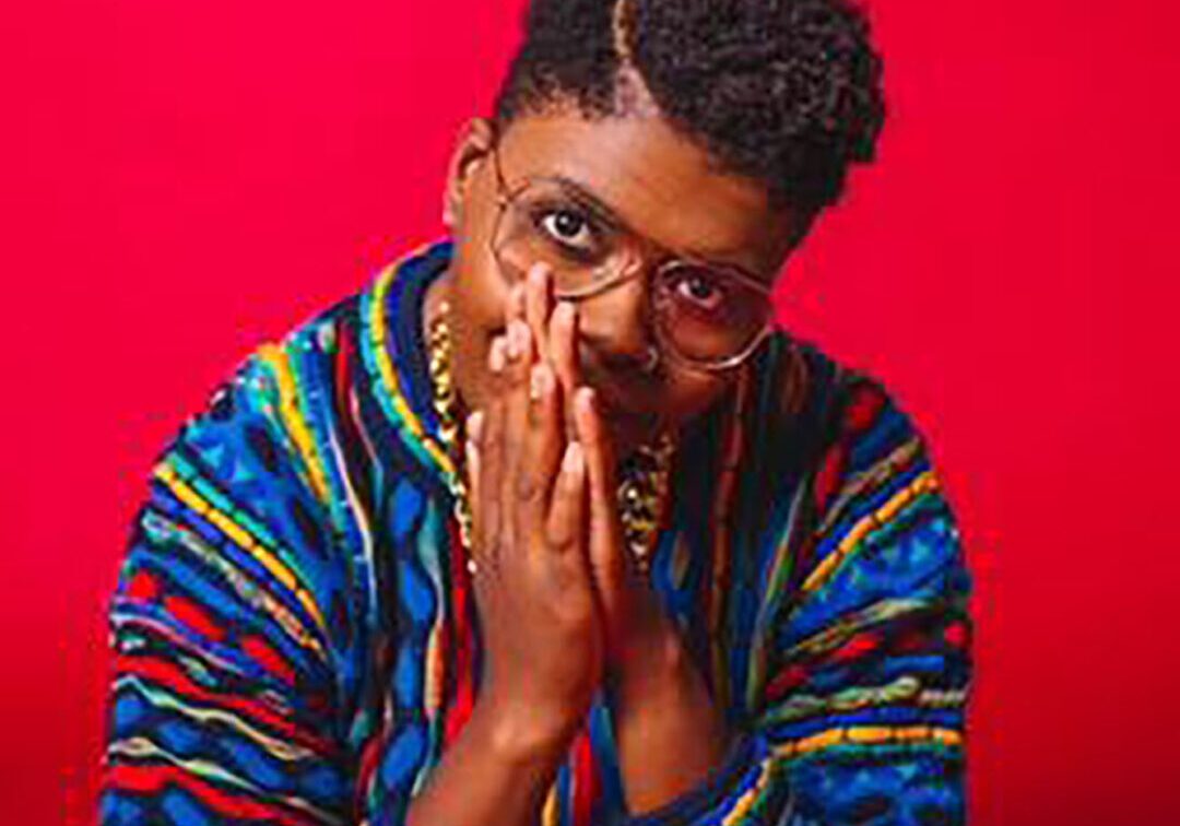 Person in colorful jacket, hands together