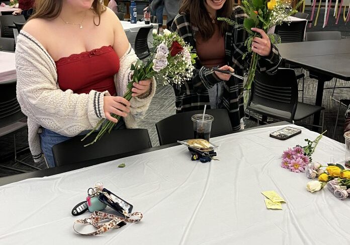 People arranging flowers at a table