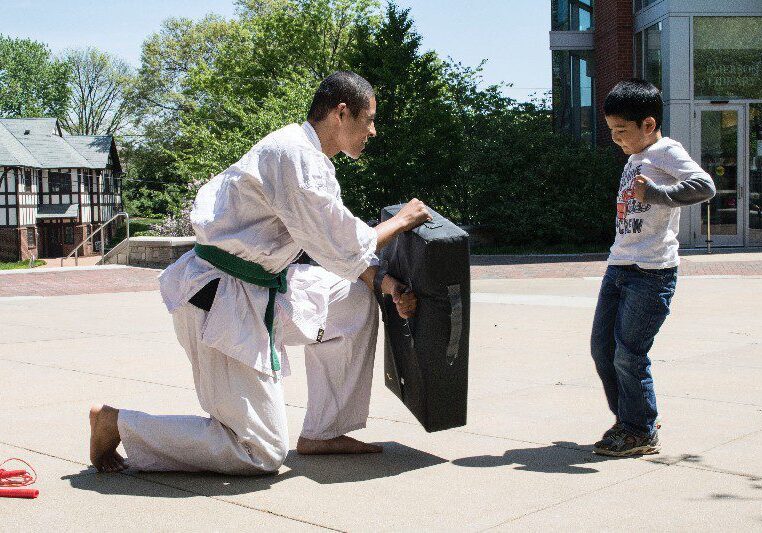 Karate student training with young boy