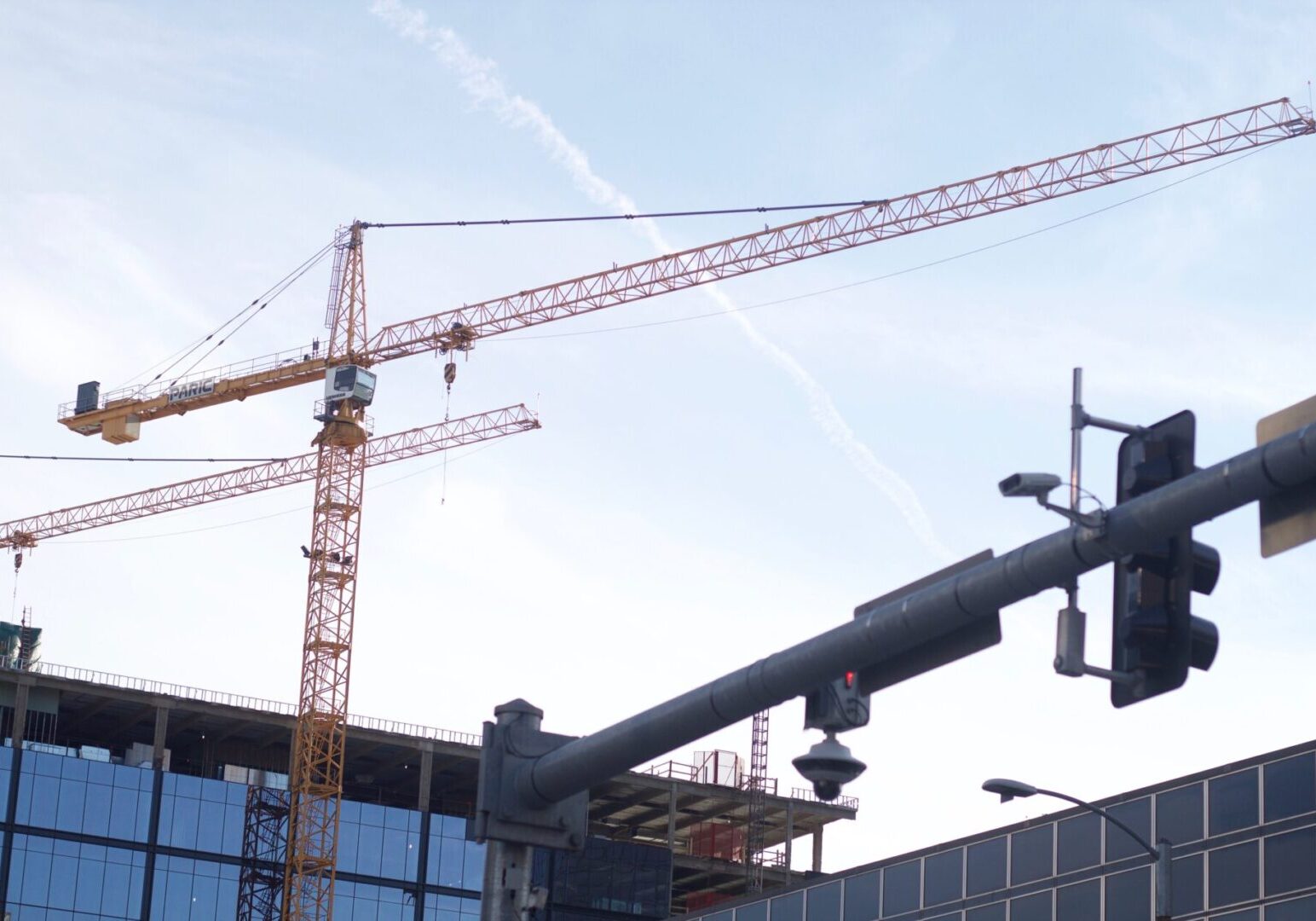 Cranes silhouetted against a blue sky