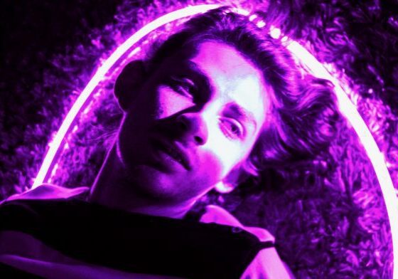 Man laying under pink neon glow