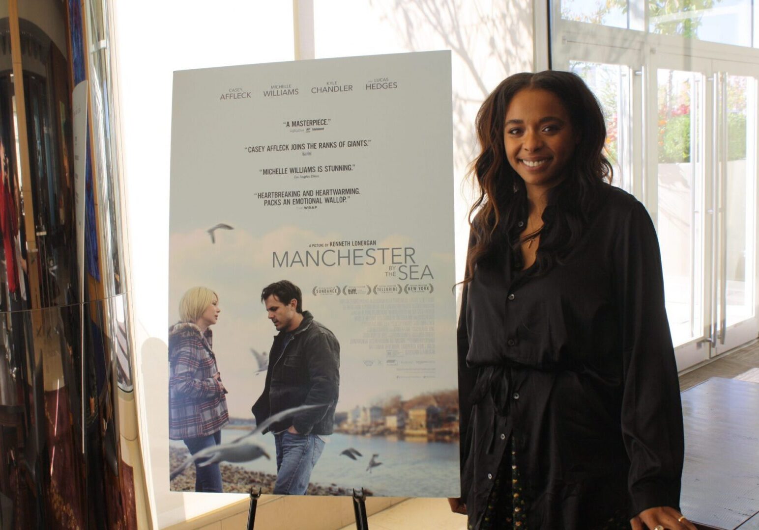 Woman standing beside movie poster