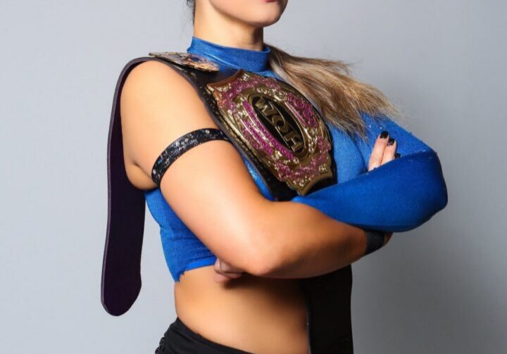 Woman holding wrestling championship belt