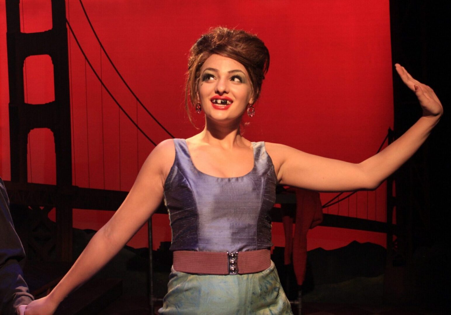 Performer on stage with red backdrop