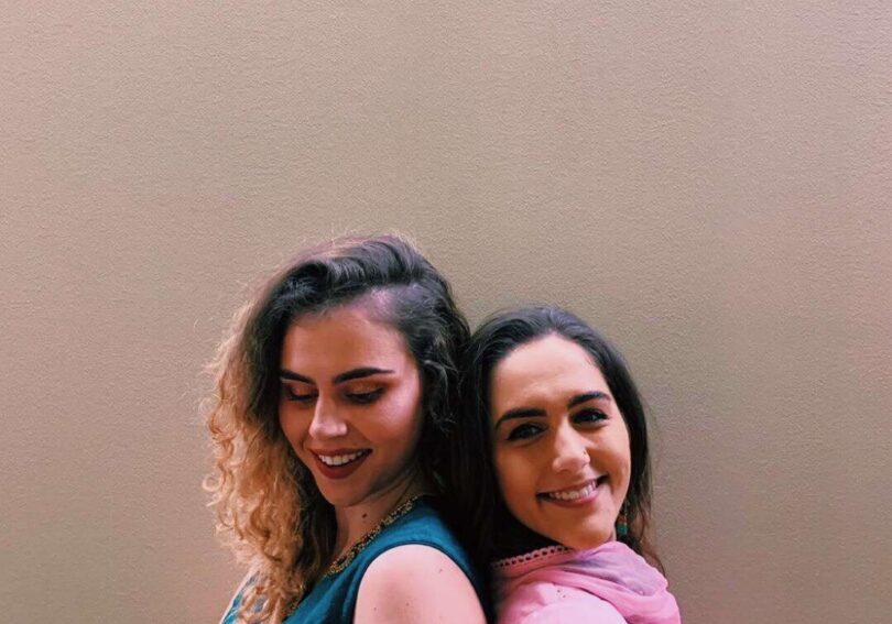 Friends smiling against a plain background