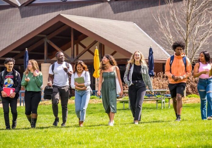 Diverse students walking on campus lawn