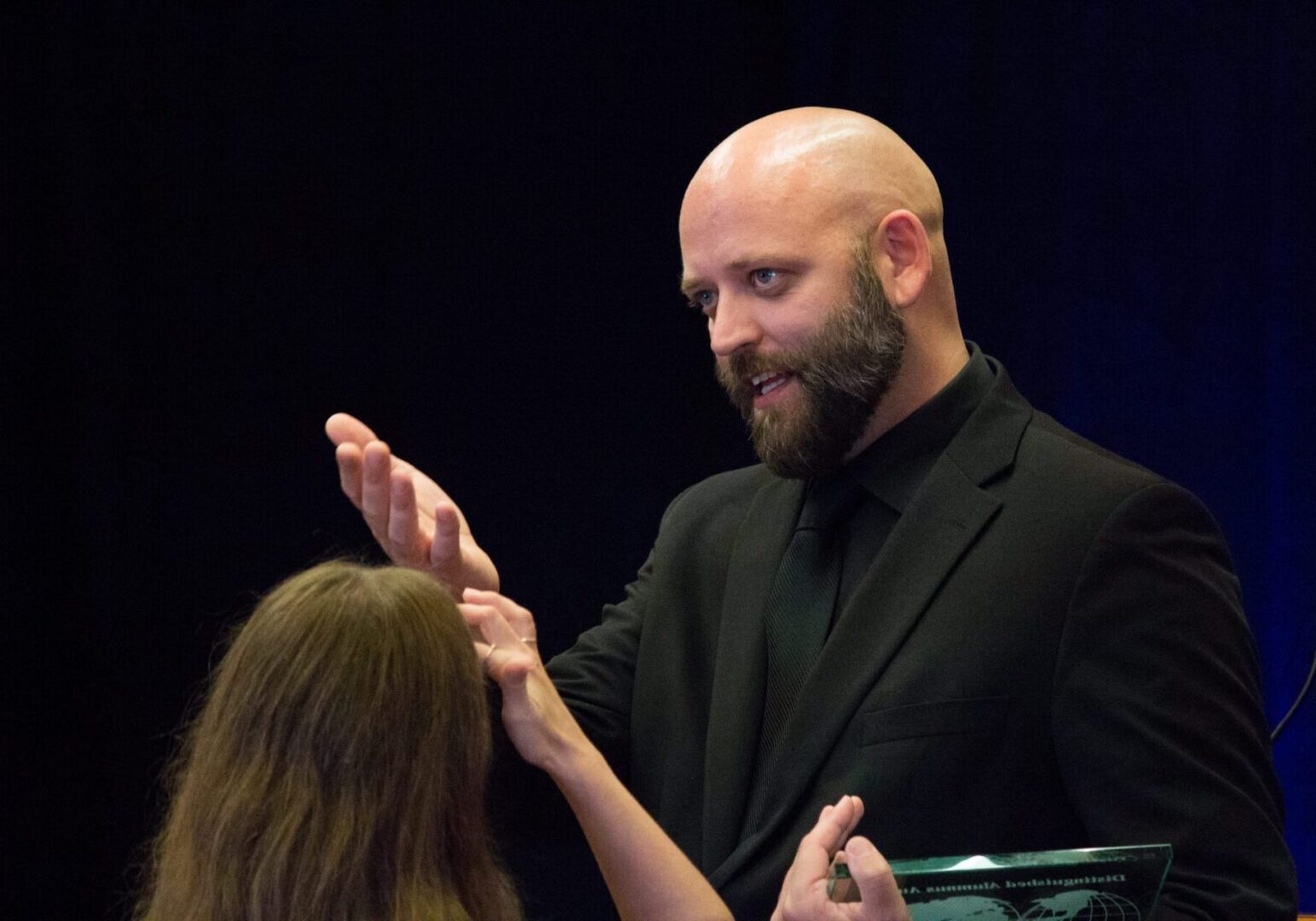 Bald man engaged in conversation
