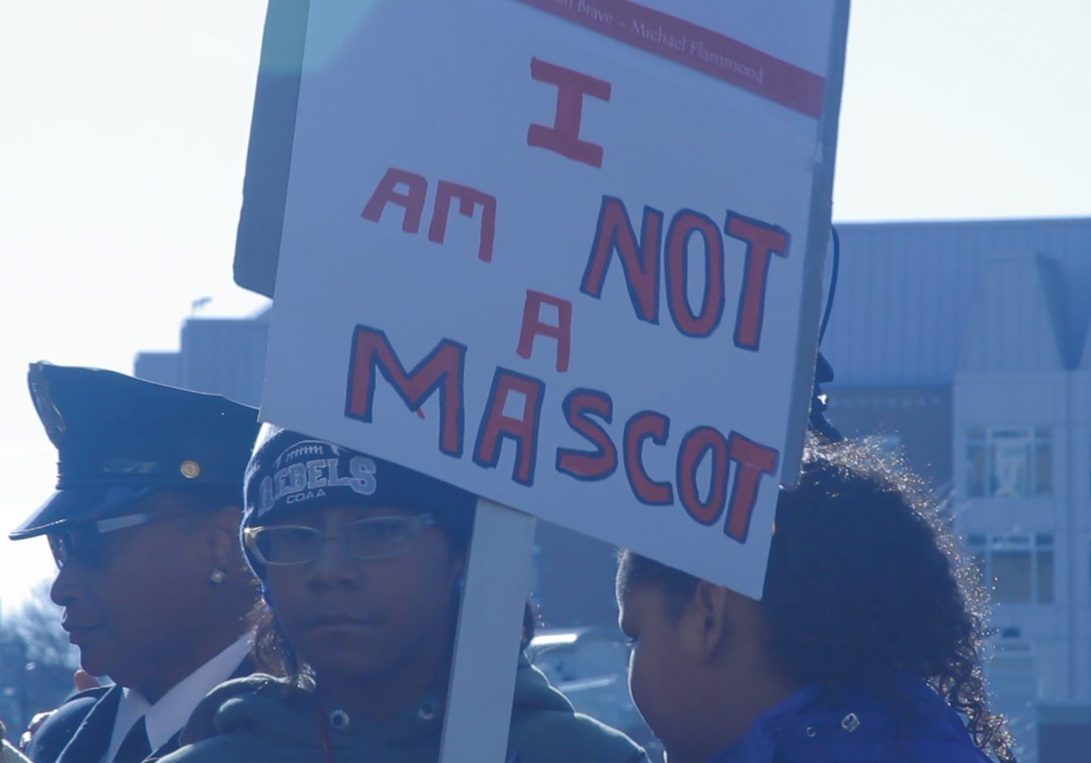 Person with protest sign in crowd.