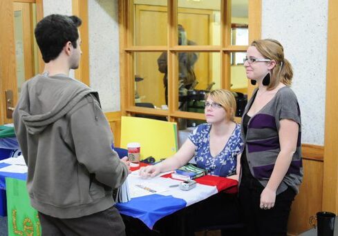 Three individuals in discussion indoors
