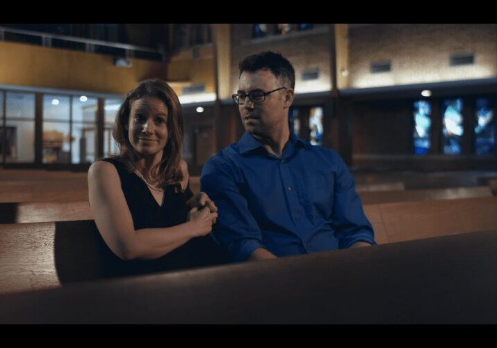 Pair sitting together in dimly lit church