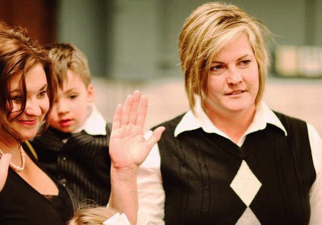 Women raising hands in a formal setting.