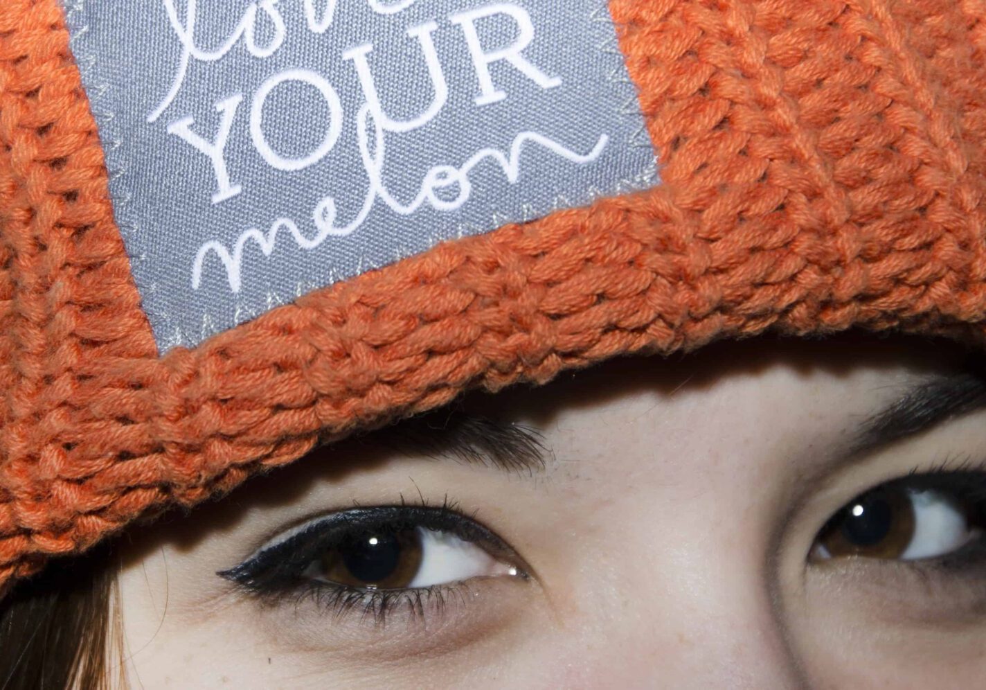 Orange knit hat with embroidered patch