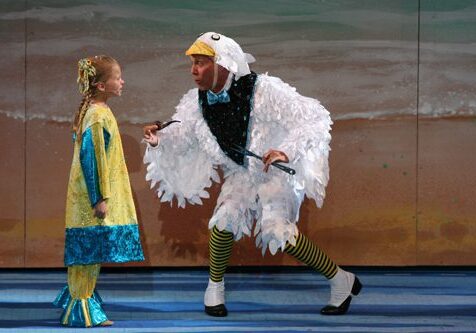 Man in bird costume performs with child