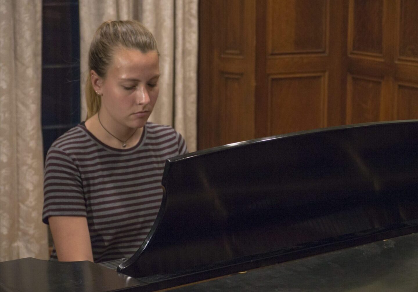Young pianist in striped shirt playing