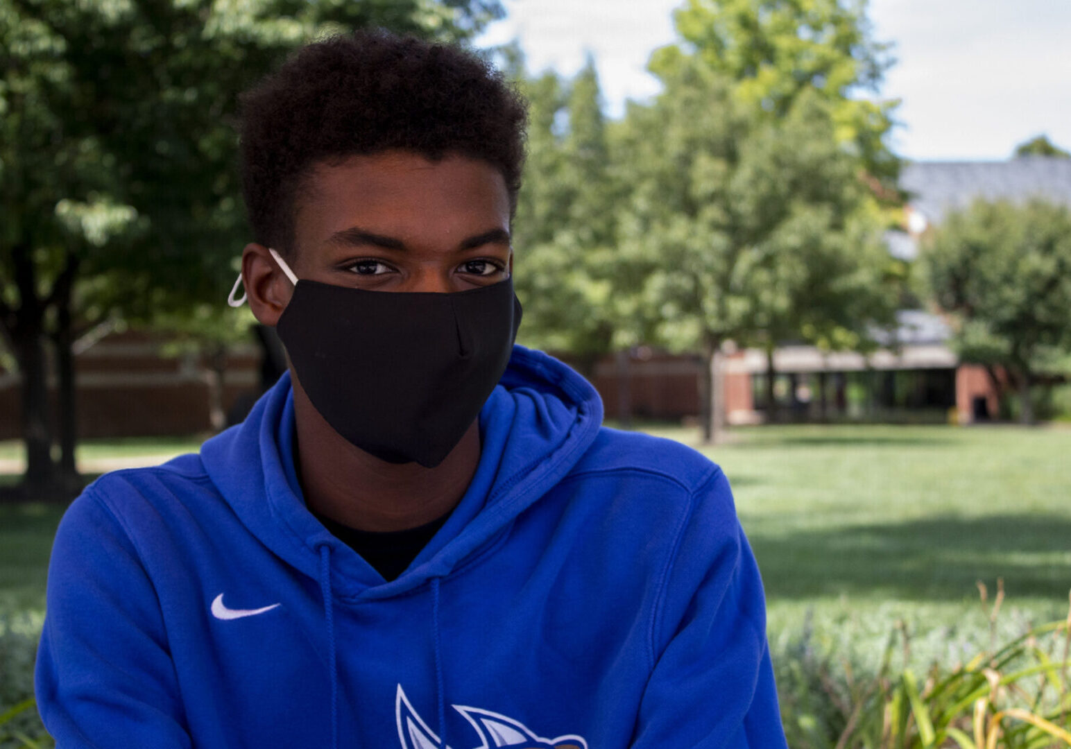 Masked person sitting in a park area