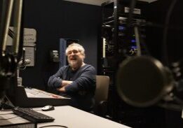 Man smiling in radio broadcasting room