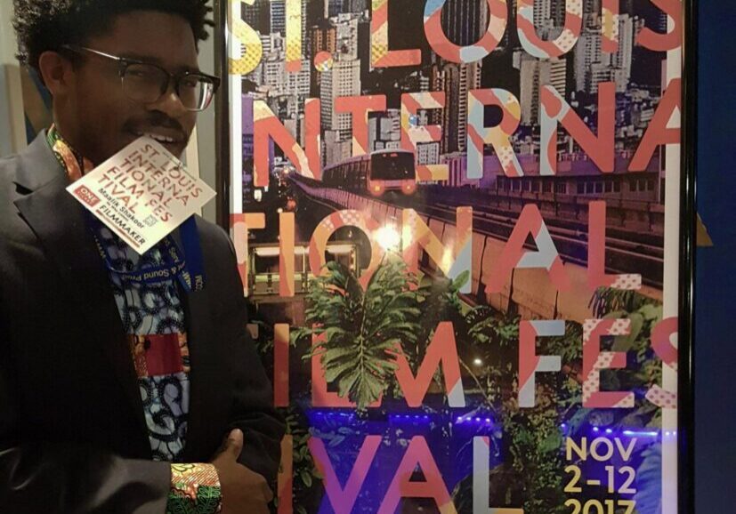 Man standing beside film festival poster